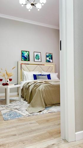 アスタナにあるЛюкс Апартаменты в самом центре Астаныのベッドルーム(青い枕の大型ベッド1台付)