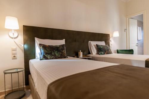 a bedroom with two beds and a headboard at Small Garden by Studio Spyros in Kanoni