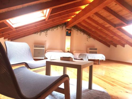 Casa Rural Villapresente في Reocín: غرفة معيشة مع كراسي بيضاء وطاولة