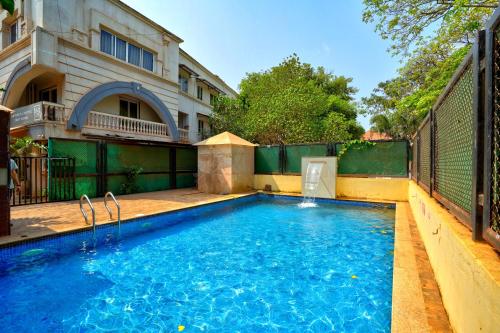 a swimming pool in front of a building at Luxurious Nirvana Apartment 2BHK in Vagator