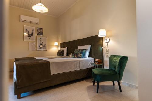 um quarto com uma cama grande e uma cadeira verde em Small Garden by Studio Spyros em Kanoni