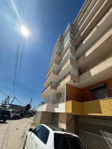 un'auto bianca parcheggiata davanti a un edificio di Join Apartment a Sarandë