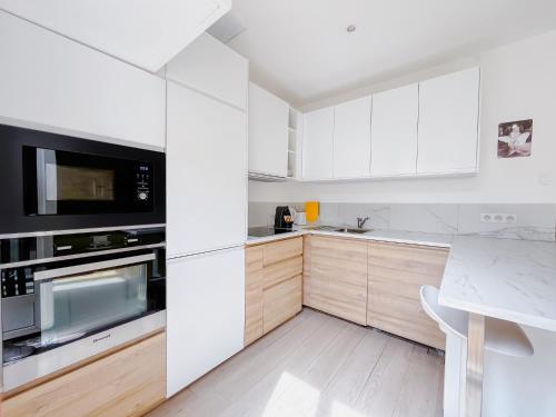 une cuisine avec des armoires blanches et un comptoir dans l'établissement Le canopée - Cozy Suquet Cannes Centre, à Cannes