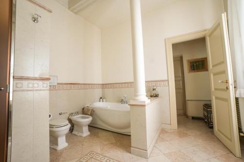 a bathroom with a tub and a toilet and a bath tub at Villa Messori Spa in Castelvetro di Modena