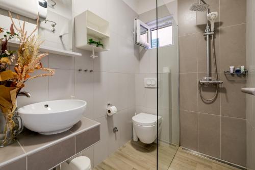 a bathroom with a sink and a toilet and a shower at Charming renovated apartment next to the sea in Šibenik