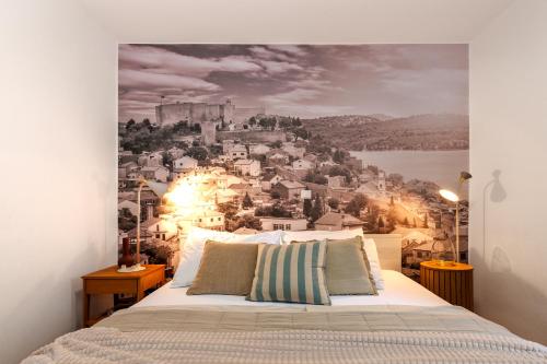 a bedroom with a wall mural of a city at Charming renovated apartment next to the sea in Šibenik