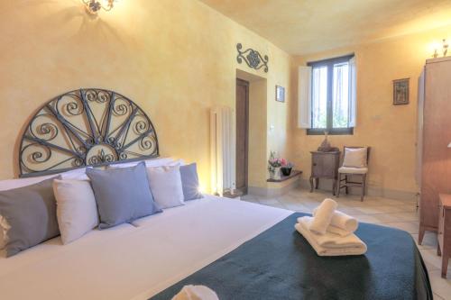 - une chambre avec un grand lit blanc et une serviette dans l'établissement Fattoria la Luna 15 min da Firenze trilocale Archetti piscina e wi-fi, à Lastra a Signa