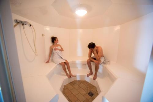 Ein Mann und eine Frau sitzen in einer Badewanne im Badezimmer. in der Unterkunft TH 615 Panoramic Hohegeiß in Braunlage