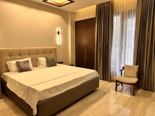um quarto com uma cama, uma cadeira e uma janela em Urban Cabin em Gurgaon