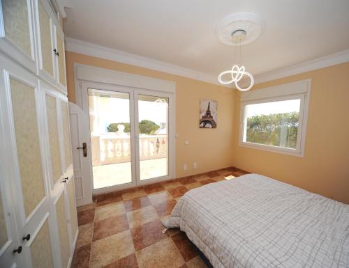 ein Schlafzimmer mit einem Bett und zwei Fenstern in der Unterkunft Villa Belgica Premium Vista Panoramica in Peñíscola