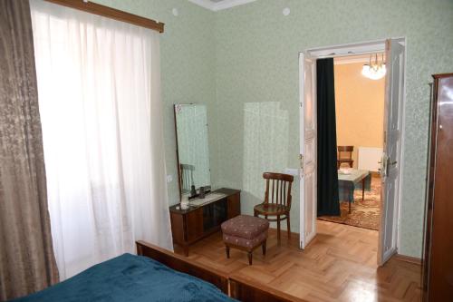 um quarto com uma cama, um espelho e uma cadeira em Nadia & Minadora em Telavi