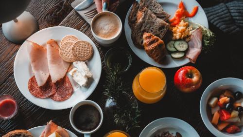 a table topped with plates of breakfast foods and oranges at Gaustablikk Fjellresort in Gaustablikk