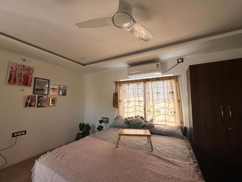 een slaapkamer met een bed, een plafondventilator en een raam bij Room stay near HAMPI in Koppal