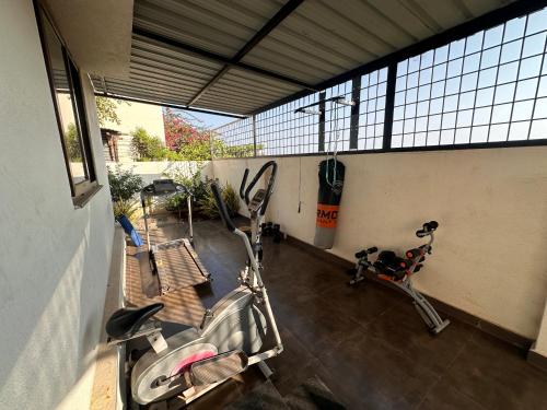 een kamer met een fitnessruimte met een fiets en een bank bij Room stay near HAMPI in Koppal