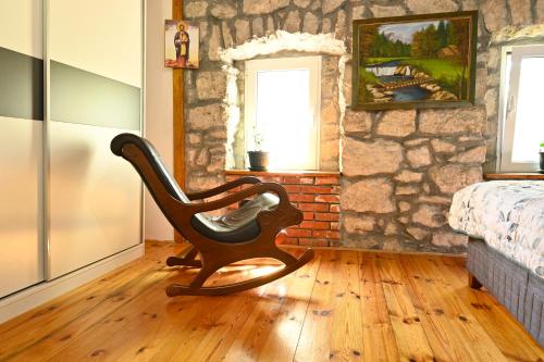 a rocking chair in a room with a stone wall at Martina in Cetinje