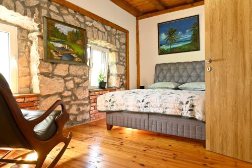 ein Schlafzimmer mit einem Bett und einer Steinmauer in der Unterkunft Martina in Cetinje