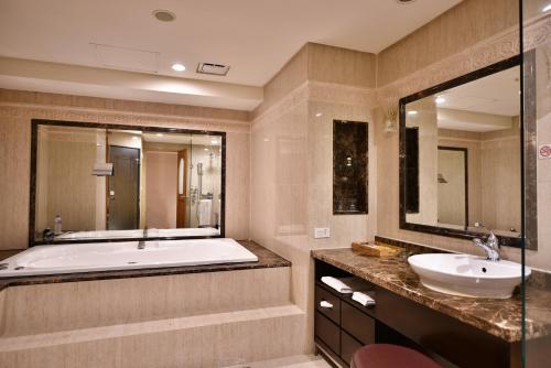 台北的住宿－台北唯客樂飯店，带浴缸、水槽和镜子的浴室