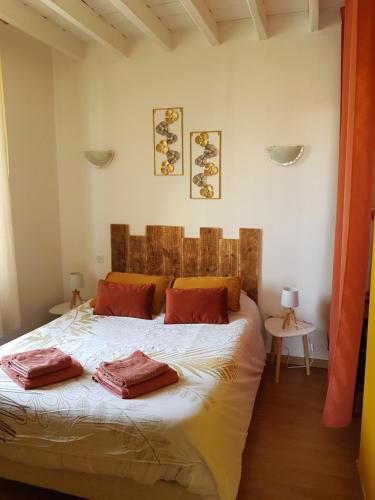 a bedroom with a bed with two pillows on it at Au jardin de Victor in Saint-Rémy-en-Bouzemont-Saint-Genest-et-Isson
