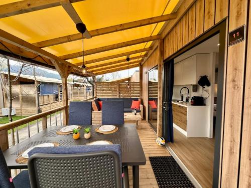 Estivo Premium Deluxe mobile homes on Camping Del Sole Village في إيزِيو: فناء مع طاولة وكراسي ومطبخ