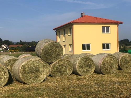 a stack of hay bales in a field next to a house at Apartment Panoramablick in Klopein am Klopeiner See