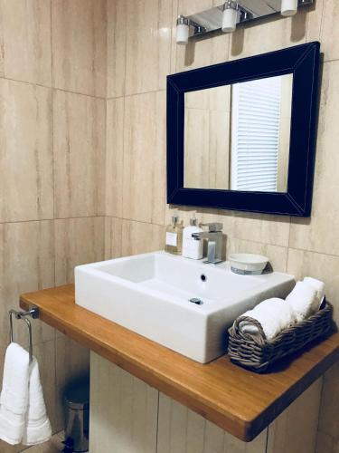 a bathroom with a white sink and a mirror at The Bakers Cottage in Armidale
