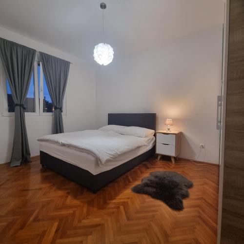 1 dormitorio con 1 cama y suelo de madera en Apartmani Katarina 4+2, en Biograd na Moru