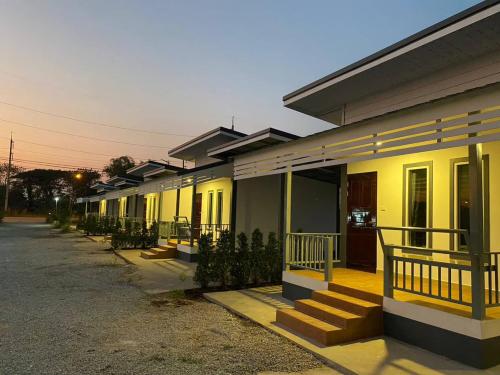 a row of houses with yellow paint on them at โรงแรมบ้านสวนวินเทจ in Ban Nam Mong