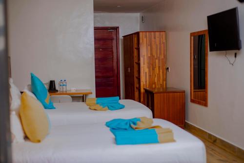 two beds in a room with blue towels on them at Centric Hotel in Kigali