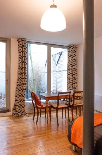 une salle à manger avec une table et des chaises et une fenêtre dans l'établissement studio d'ALO, à Clamart