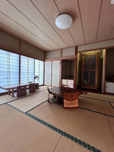 a large room with a table and a tv at 然舎(ZENSYA)お茶場隣の一軒家。自然の中BBQもできます。高速、駅近いラッキー in Kakegawa