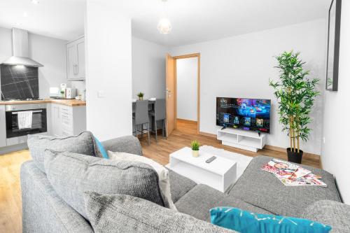 AmblecoteにあるTwo Bed Apartment - Two Parking Spaces - Stourbridge - Top Rated - Netflix - Wifi - 1BSのソファとテレビのあるリビングルーム