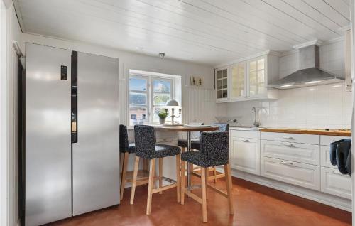 a kitchen with a refrigerator and a table with chairs at Lovely Home In Sæby With Sauna in Sæby