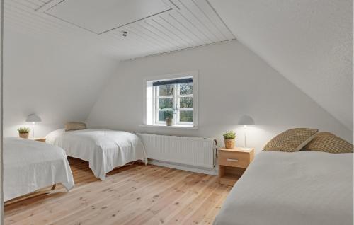 a white room with two beds and a window at Lovely Home In Sæby With Sauna in Sæby