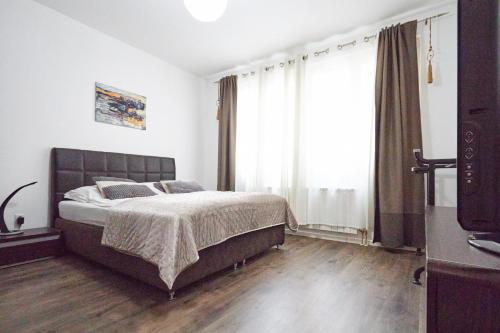 een slaapkamer met een bed en een groot raam bij Old Town Elegance Sarajevo in Sarajevo