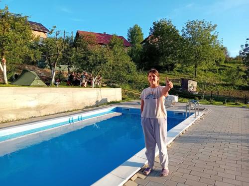 een jonge jongen die naast een zwembad staat bij Bungalovi Lana in Sarajevo