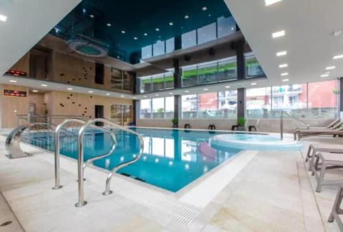 a large swimming pool with escalators in a building at Apartament Holiday Crystal in Rewal