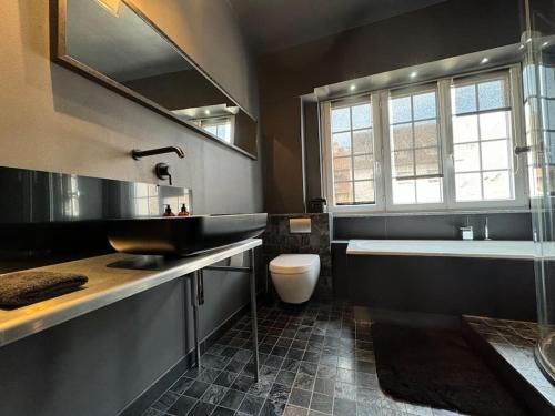 une salle de bains avec lavabo, baignoire et toilettes dans l'établissement L'Arsenal - Appartement Centre ville - Poche commerces & restaurant - 6 P, à Sélestat