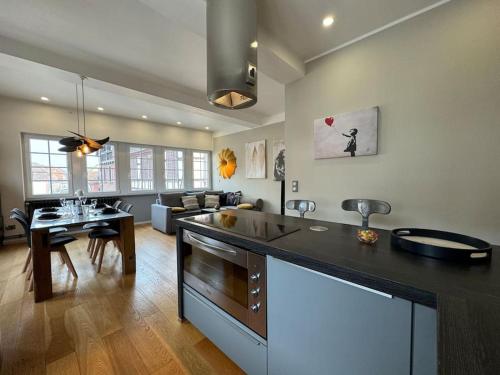 - une cuisine et un salon avec un grand comptoir dans l'établissement L'Arsenal - Appartement Centre ville - Poche commerces & restaurant - 6 P, à Sélestat