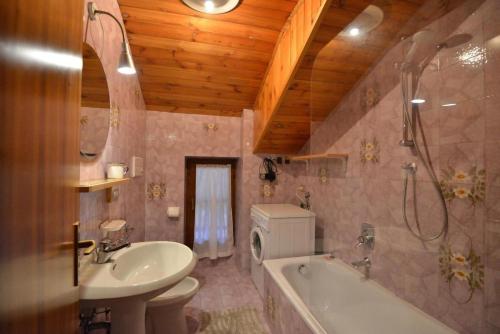 een badkamer met een wastafel, een bad en een toilet bij Casa Faè Dolomiti in Madonna di Campiglio