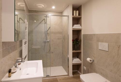 La salle de bains est pourvue d'une douche, d'un lavabo et de toilettes. dans l'établissement Residence Casa Coppa Appartamento Jasmine, à Omegna