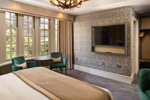 a hotel room with a bed and a flat screen tv at Brig o' Doon House Hotel in Ayr