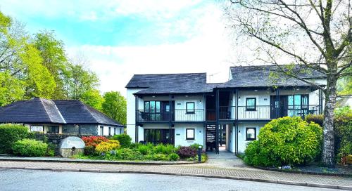 a large white house with a black roof at Quaysiders Lakes Resort - Quaysiders Club in Ambleside