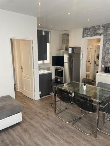 a living room with a glass table and a kitchen at Mary's Hotel République in Paris