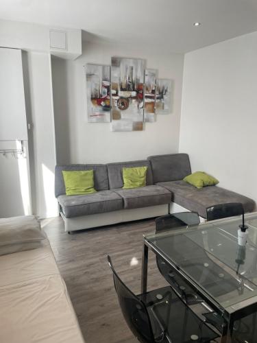 a living room with a couch and a glass table at Mary's Hotel République in Paris