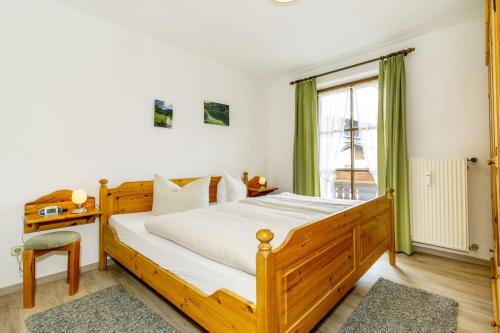 ein Schlafzimmer mit einem Holzbett und einem Fenster in der Unterkunft Ferienwohnung Froböse in Reit im Winkl