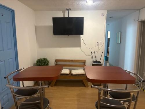 Una habitación con dos mesas y un sofá con un televisor en la pared. en bnb2night Polanco-Metro, en Ciudad de México