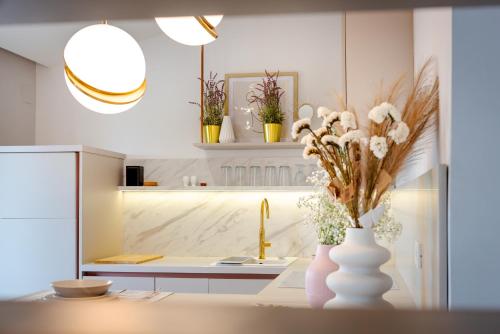 eine Küche mit einer weißen Vase mit Blumen darin in der Unterkunft DANICA Luxury SeaSide Apartment in Šibenik