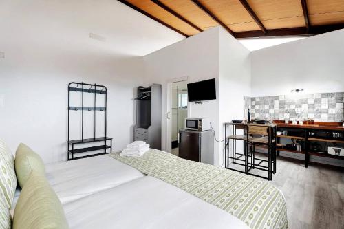 um quarto com 2 camas, uma secretária e um lavatório. em Charming and comfortable apartment Casa Lomo El Aire Helecho em Tegueste