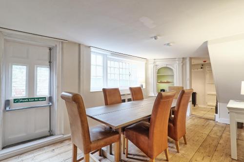 a dining room with a wooden table and chairs at Ranfield's Brasserie Hotel Rooms in Coggeshall