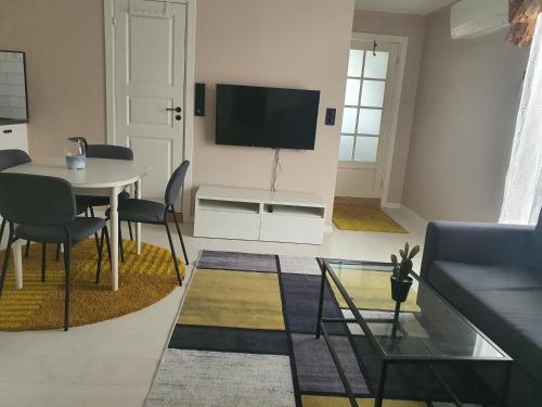 a living room with a table and a tv on a wall at Hanaborg apartment in Lorenskog